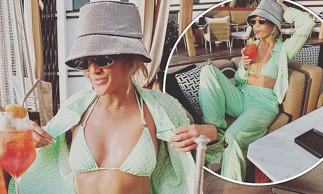 Bikini-clad , Ashley Roberts flaunts her incredible figure in a chic green outfit while sipping an Aperol Spritz on a trip to Dubai