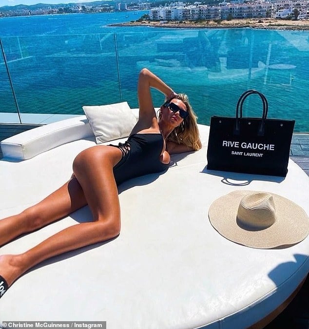 Christine McGuinness, 35, shows off her long legs in a black swimsuit as she relaxes on a sun-soaked holiday