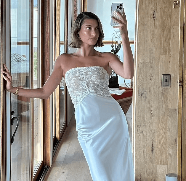 On Wednesday, Hailey Bieber, who was out with friends in Malibu, snapped a glorious mirror selfie while wearing a stunning bridal slip dress.