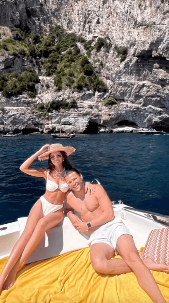 In a video posted by Mark, Michelle showed off her endless legs and rock hard abs in a white two-piece bikini with a strapless top and high-waisted bottoms.