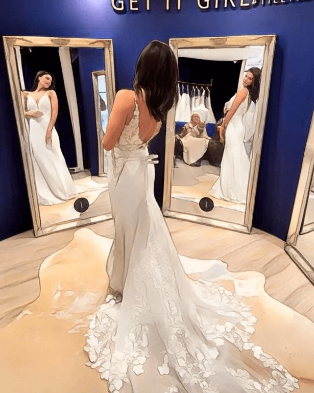 She looked stunning in one eye-catching gown that was cinched in nicely at the waist and featured a floral-print train as she admired the gowns in her mirror.