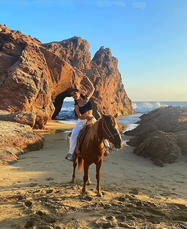 As she galloped along the glistening ocean, Salma Hayek wore a black sports bra and white low-rise pants while riding off into the sunset in Mexico.