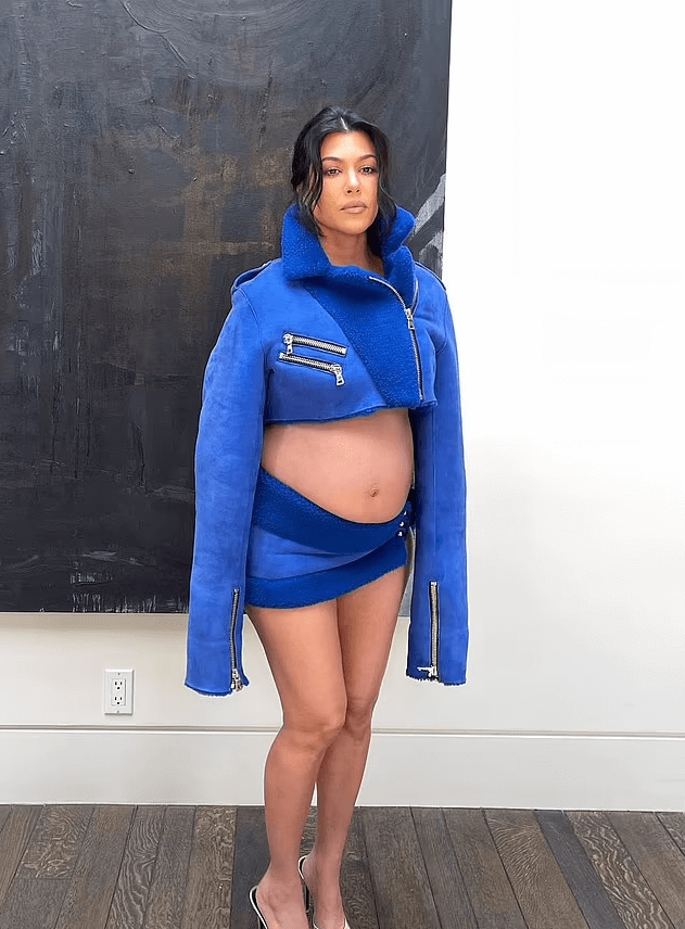In a cropped blue jacket and matching mini skirt, Kourtney Kardashian showcases her maternity style