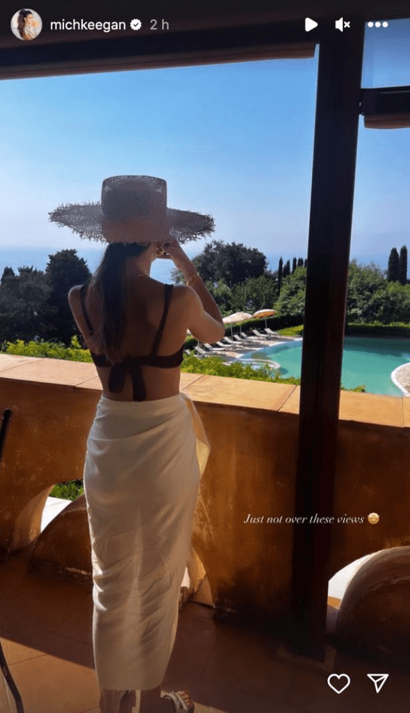 Another picture showed her wearing a black bikini top and white sheer skirt while looking out of her balcony onto the pool.