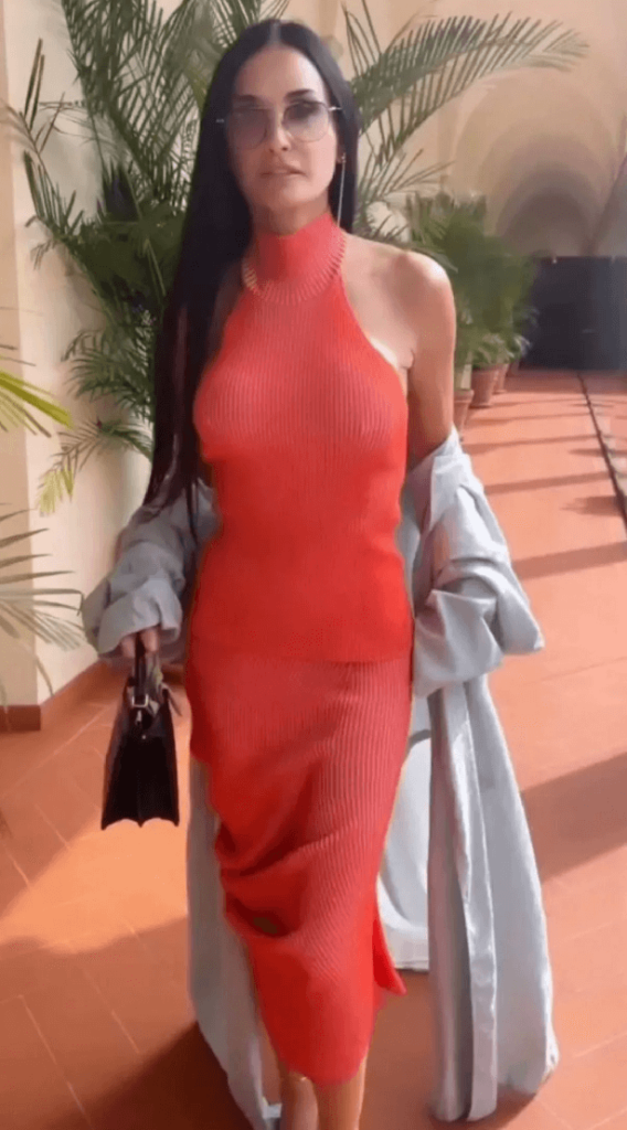 As Demi Moore exhibited her incredible figure in a see-through red dress at Milan Fashion Week, she left fans feeling a bit hot under the collar.