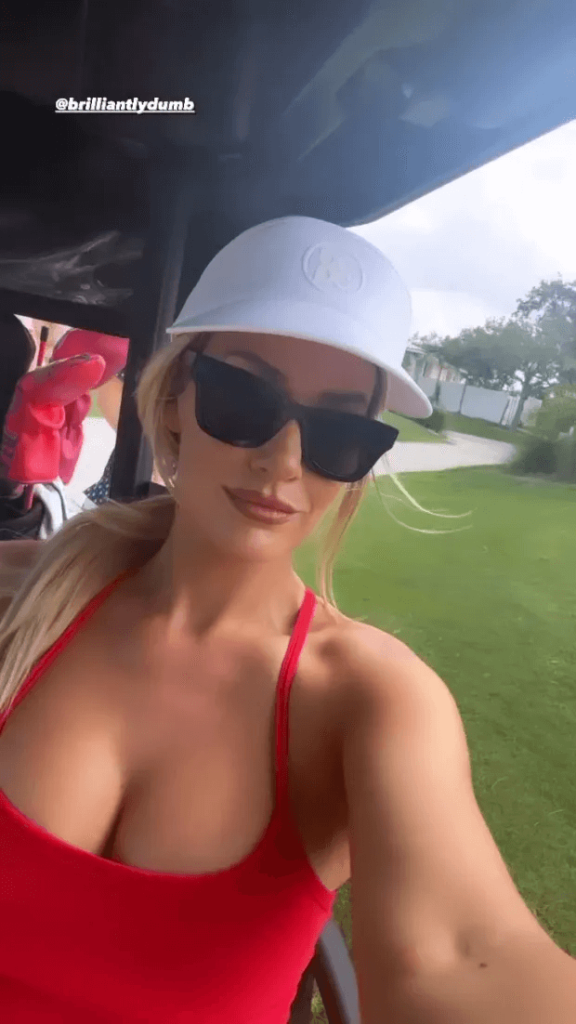 Taking to the fairway with her friend Robby Berger, Paige Spiranac wore a low-cut red dress and displayed a bust of curves.