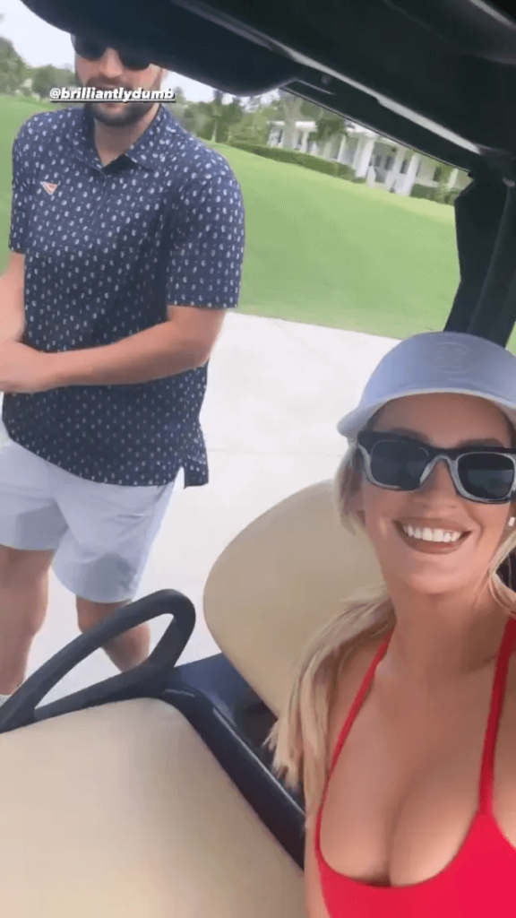 She sat in a buggy wearing a white hat, black sunglasses, and a figure-hugging outfit.