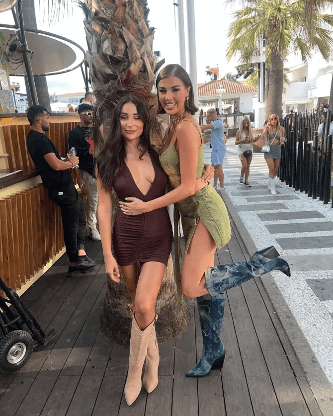 In the photos, the 27-year-old TV personality wore a plunging brown dress showing off her curves while partying with friends in Ibiza.