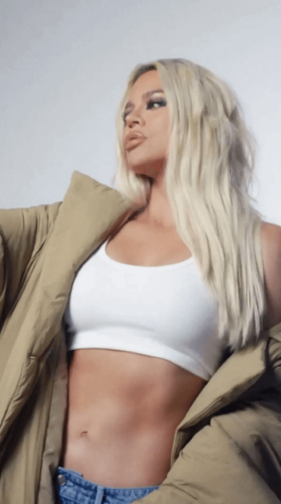 A steamy clip shows Khloe Kardashian in teeny white sports bra exposing her body