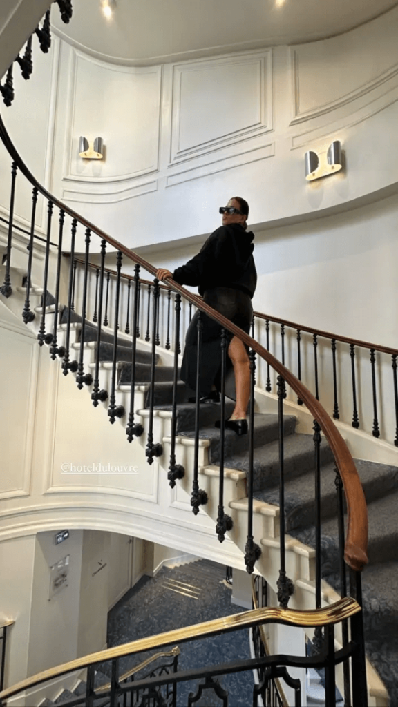 The following picture shows Ashley's toned legs in the large slit of her maxi skirt as she walks up a spiral staircase in the five-star hotel.