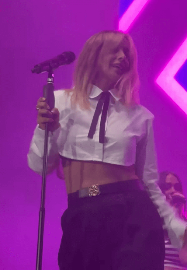 In a series of snaps, she wore a cropped white shirt revealing her toned abs and paired it with fitted black trousers and pointed black boots.