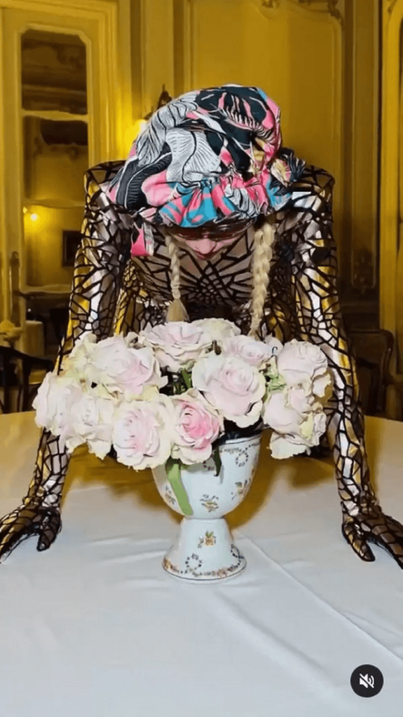 In a skin-tight vibrant  bodysuit, Madonna wobbles on table, leaving fans stunned