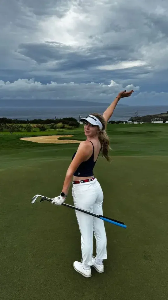 A plunging navy crop top and tight white pants were worn by Grace Charis as she showed off her incredible figure while playing golf.