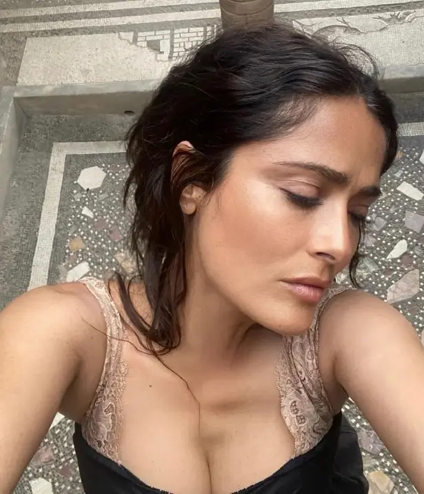 While on vacation in Italy, Salma Hayek ditched her bra and wore a plunging lace dress.