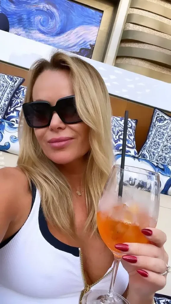 Amanda celebrated her birthday in absolute style earlier this week. She poses in a pretty white swimsuit and stylish black sunglasses at the beach and pool.