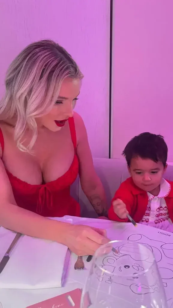 In a plunging red dress, Helen Flanagan, 33, revealed her stunning figure as she played with her youngest child.