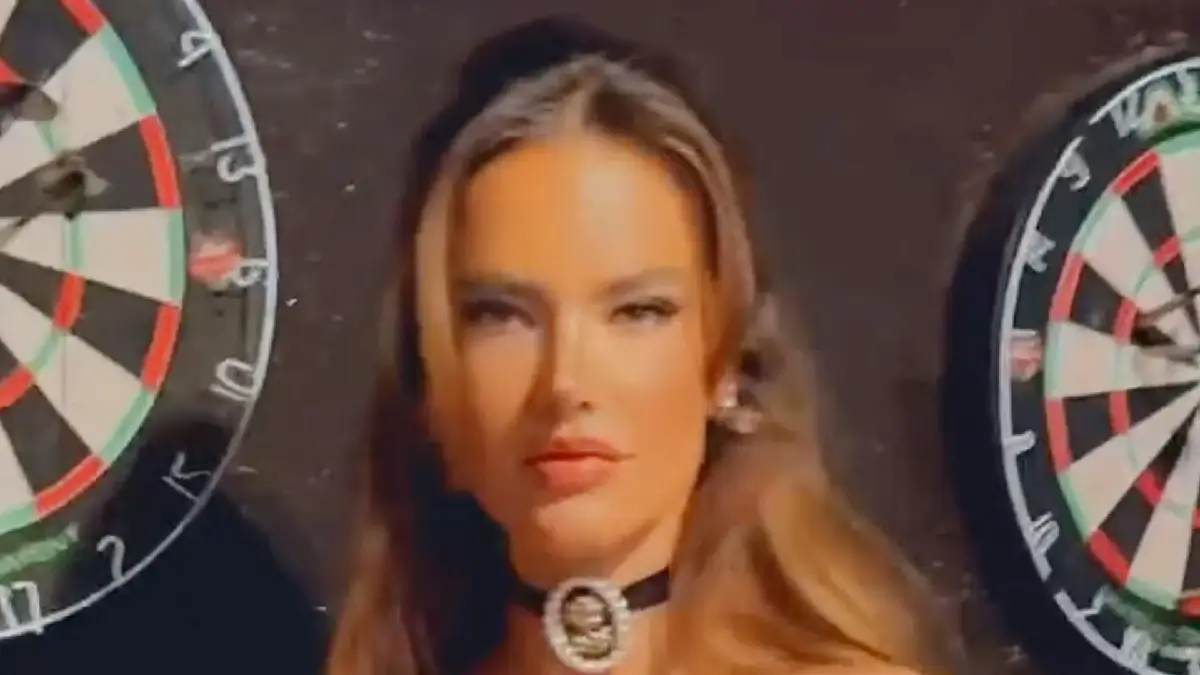 With just a leather corset and fishnets, Alessandra Ambrosio shows off plenty of her ample cleavage and gaming skills