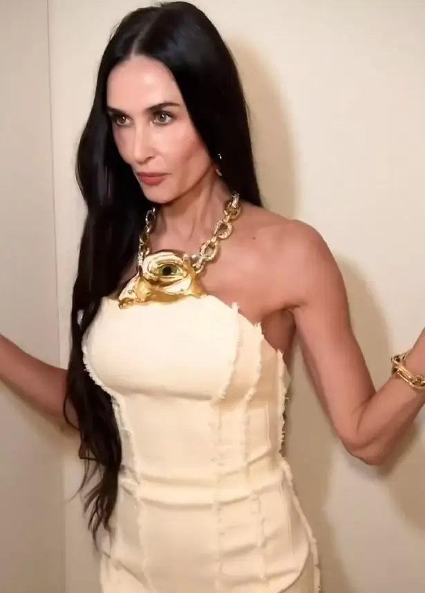 Demi Moore showed off her sculpted figure and toned arms while wearing a fitted cream dress with a chain necklace on Instagram.