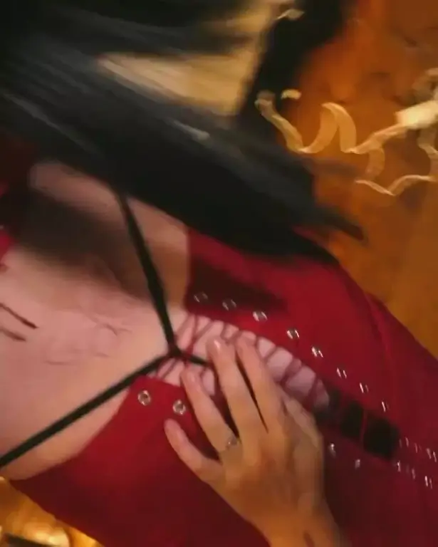 In another video, Perry can be seen being strapped into her outfit and having the corset strings tied up, all the while focusing on a scarification-looking prosthetic on her lower back.
