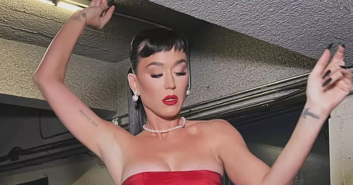 In a red corset skirt with an open back, Katy Perry squeezed her famous figure into the tight lace up outfit