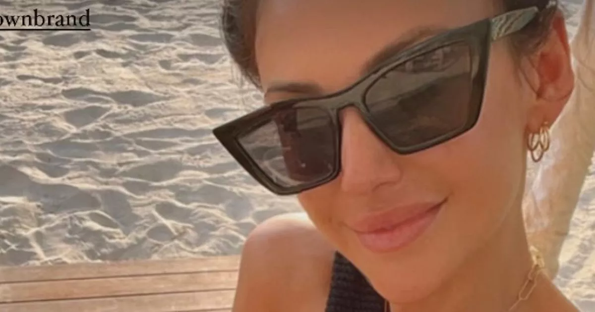 Michelle Keegan shows off her stunning figure in a black bikini and halterneck top as she snapped on the beach