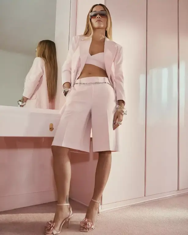 For her latest Primark campaign, Rita Ora wore a teeny pink  crop top paired with a matching blazer and trousers to shows off her toned body.
