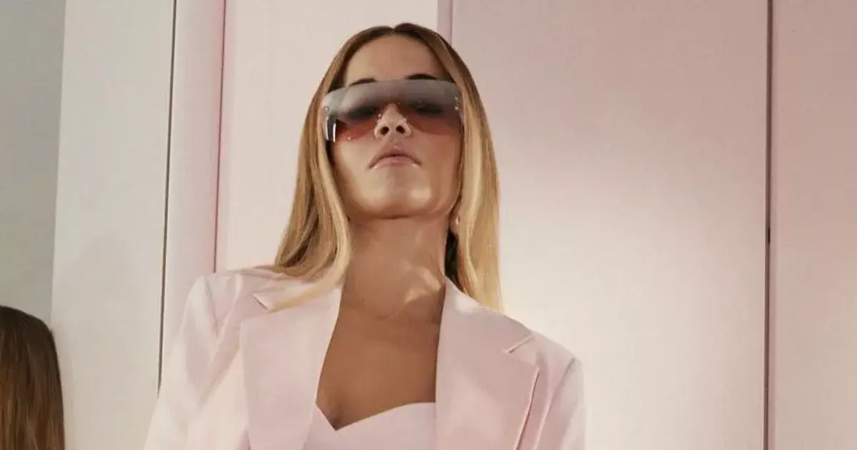 Rita Ora shines in a teeny pink crop top and blazer as she shows off her toned body