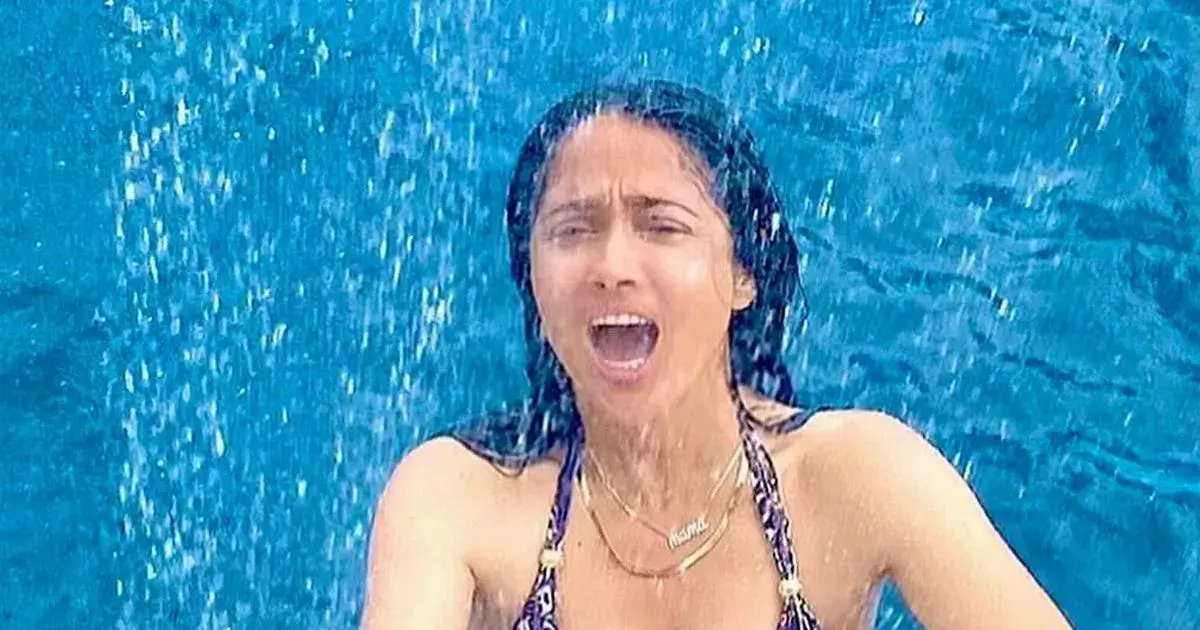 A plunging swimsuit exposes Salma Hayek’s curves as she’s hailed as ‘the most beautiful lady’