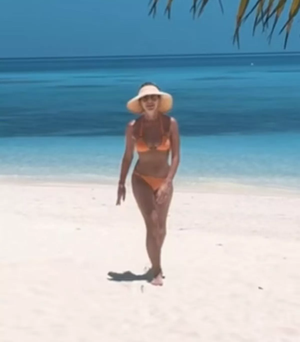 Holden was filmed wearing a tiny orange bikini and swinging on a palm tree in the series of clips and snaps.