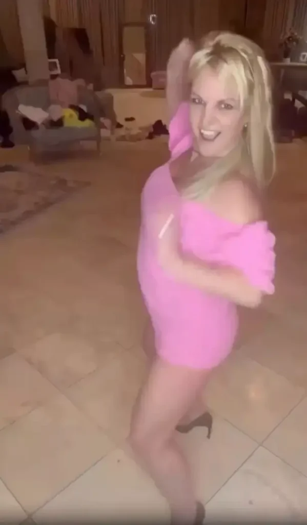 A different clip showed the hitmaker dancing to the same song, but this time wearing a pink mini dress with giant puffy sleeves and a plunging blue bra.