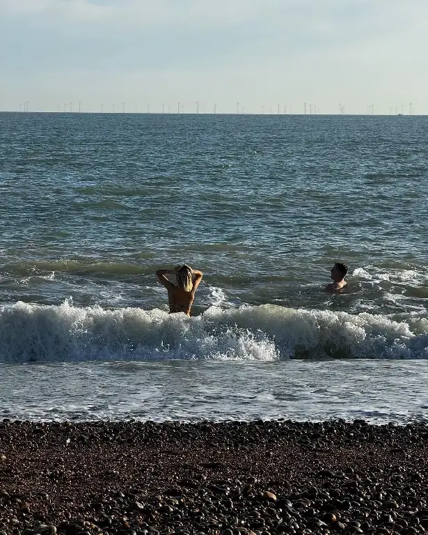 Danni, whose blonde locks are slicked back, is also seen sprinting toward the sea in another snap.