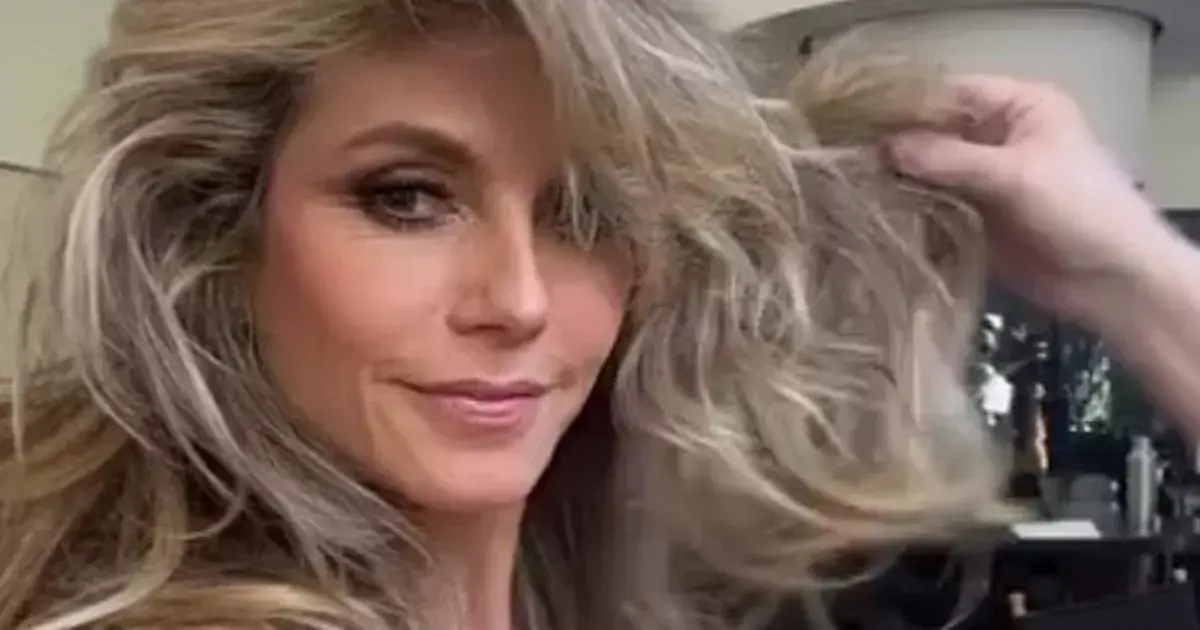 Heidi Klum sends temperatures soaring as she rocked a blue shirt which she only buttoned half way up to reveal a black lace bra underneath