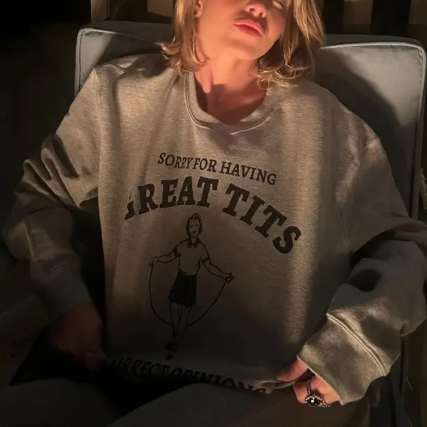 As seen in one of her snaps, Sydney Sweeney wears a grey sweatshirt with the words 'Sorry for having great t*ts' on the front.