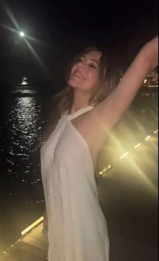 Elizabeth Hurley walked along the moonlit stroll at night wearing a sheer white summer dress and ditched her bra .