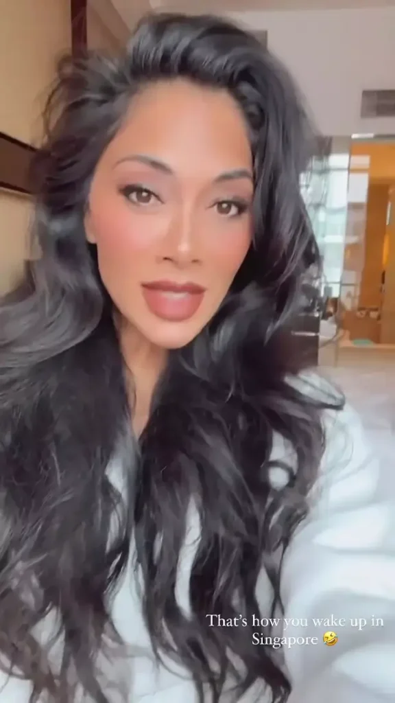 In a recent behind-the-scenes video, Nicole Scherzinger can be seen keeping warm in a fluffy white robe as she records a close-up of her face.