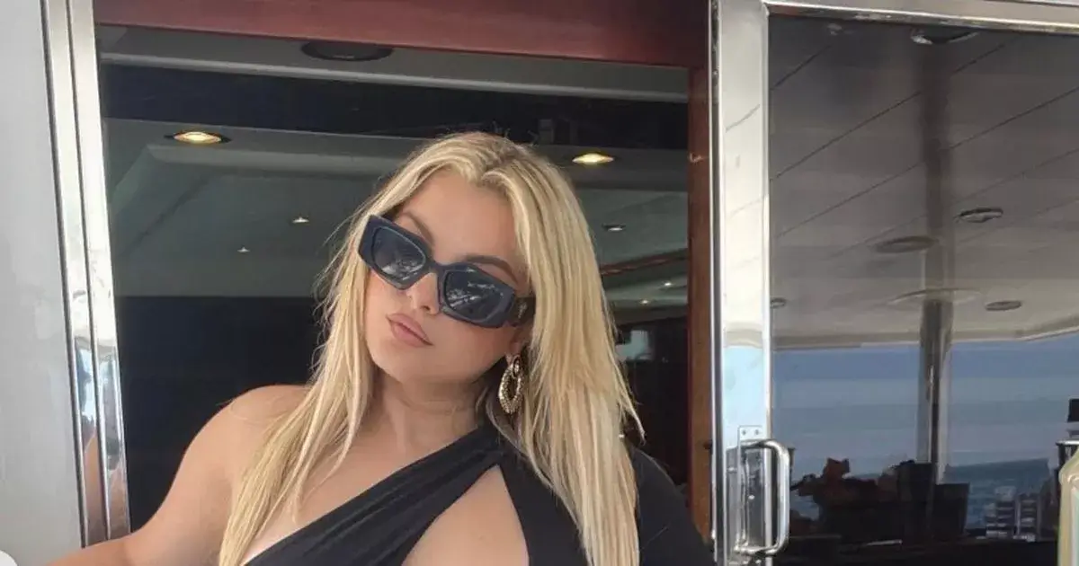 In a black monokini, Bebe Rexha sunbathing topless while displaying her curves during a luxurious accommodations