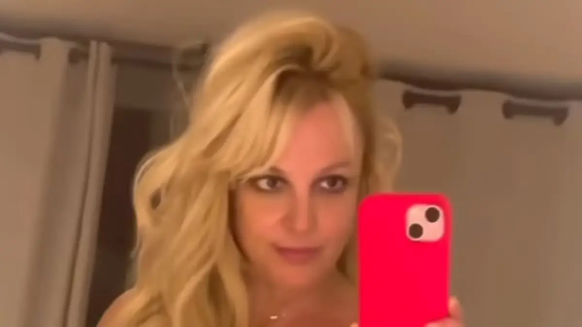 Playing dress-up, Britney Spears displays two daring mini dresses as she posing in front of a floor-length mirror