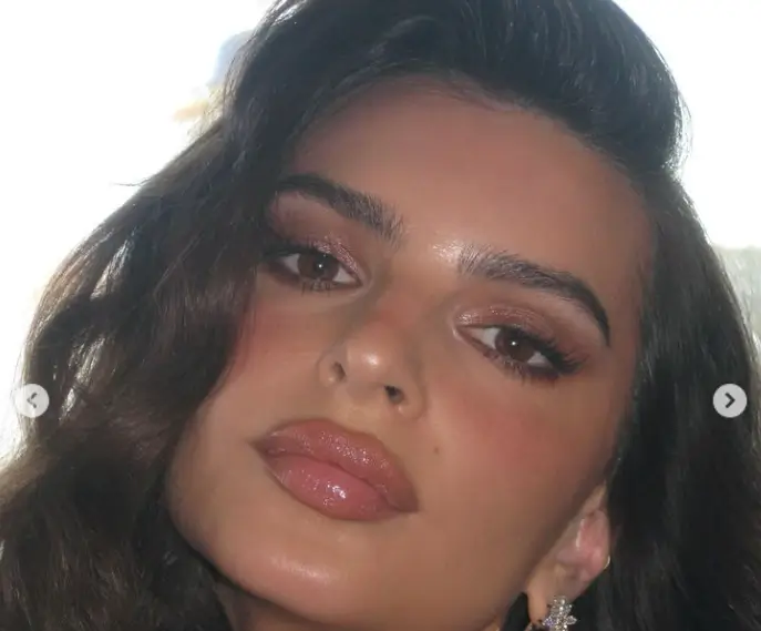 Emily Ratajkowski smoldered in a plunging dress, flashing her braless assets while clinging to the speedboat’s railings as she enjoyed the sunset