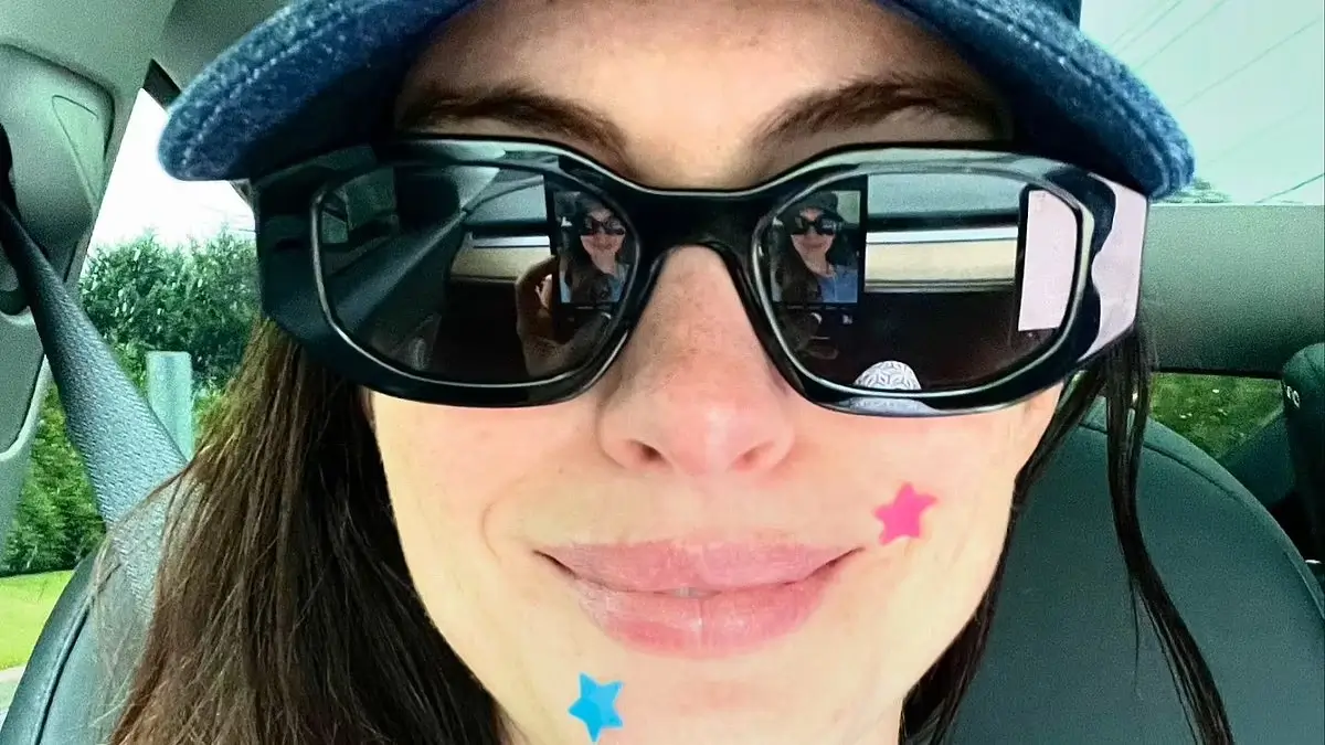 Anne Hathaway wore stylish black sunglasses and a denim cap over her head showing off her natural beauty along with colorful pimples.