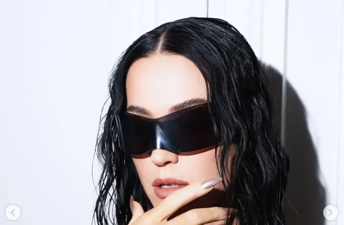 Katy Perry stunned in a leather knee-high boot and a funky midi dress adorned with zipped bag straps and halterneck designs