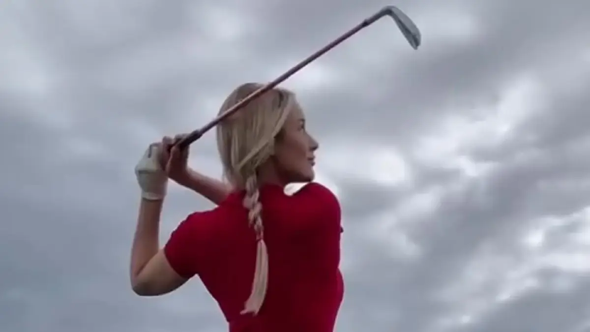 Paige Spiranac, 31, shows off her golf swing while wearing a tight red playsuit without a bra