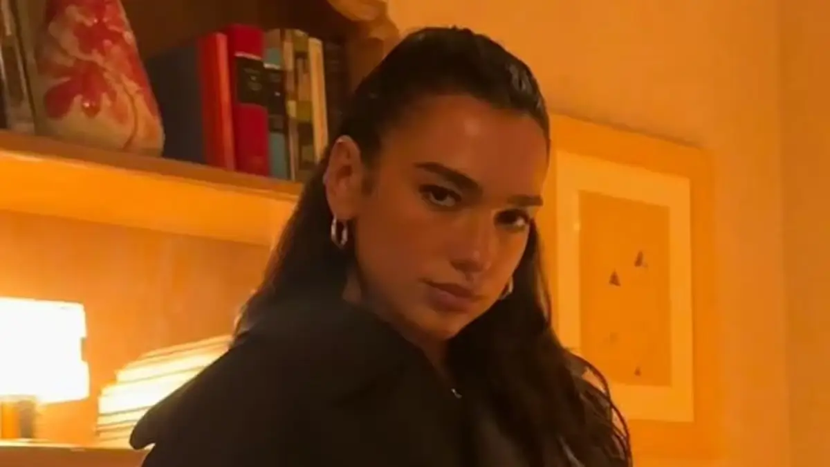 Dua Lipa showed her long legs in a black bodysuit, sheer tights, and high heels in a series of racy photos
