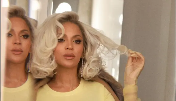 Beyonce cut a glitzy figure in a figure-hugging yellow top and matching satin skirt as she posed for fans