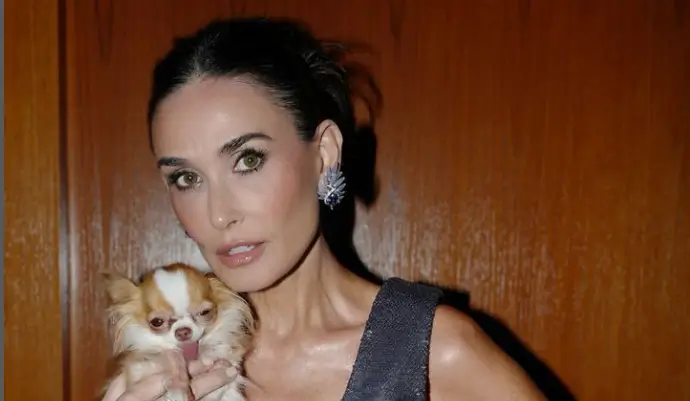 Demi Moore stunned as she showing off her toned arms, cleavage, and minuscule waist in a figure-hugging plunging Prada dress