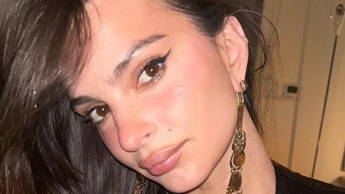 Emily Ratajkowski shows off her stunning figure in a sleeveless black dress with a daring plunge neckline as she shared a series of sultry snaps