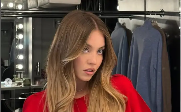 Sydney Sweeney looks stunning as she shows off a ruby-red mini dress, perfect for setting the stylish season