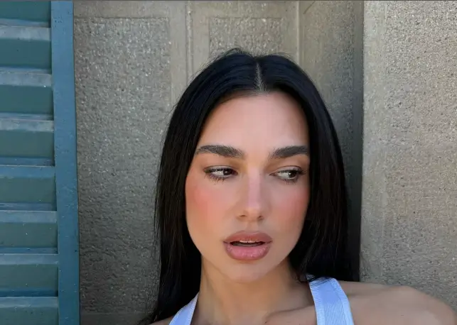 Braless Dua Lipa looked stunning as she showcased her slender physique in a revealing tank top adorned with bold black lettering