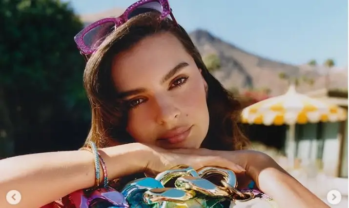 While waist-deep in an outdoor pool, Emily Ratajkowski showed off her toned abs and cleavage as she held up a luxurious purse for the perfect Instagram photo