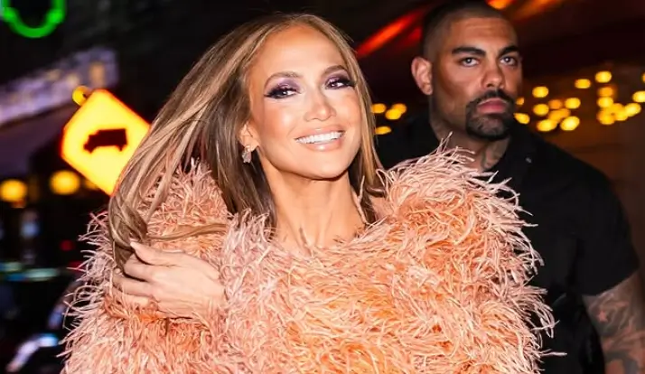 Braless Jennifer Lopez suffers a nip slip in a plunging peach dress as she attended the benefit concert in NYC
