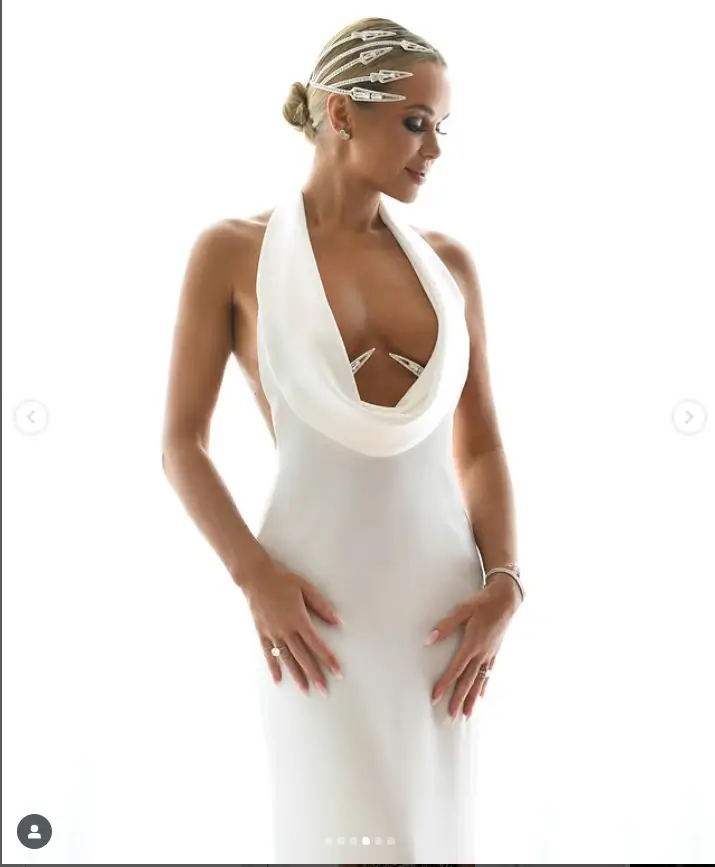 Her choice of attire, a white satin halterneck gown by Saint Hendrix, was a testament to her fashion prowess. The gown's figure-hugging design was complemented by elegant white heels, while her hair was styled in a sleek kow bun. A striking diamante head piece completed her ensemble.